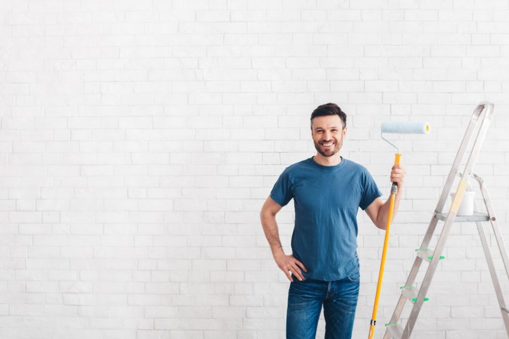 happy-man-preparing-for-paint-new-apartment-walls-of-bricks.jpg